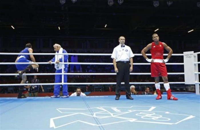 Ali Mazaheri (trái) của Iran rời khỏi sàn đấu trước khi trọng tài công bố quyết định người chiến thắng. Mazaheri bị truất quyền thi đấu ở nội dung boxing nam hạng 91kg trước Jose Larduet Gomez (phải) của Cuba.